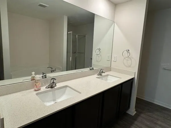 a bathroom with a double vanity sink and a mirror
