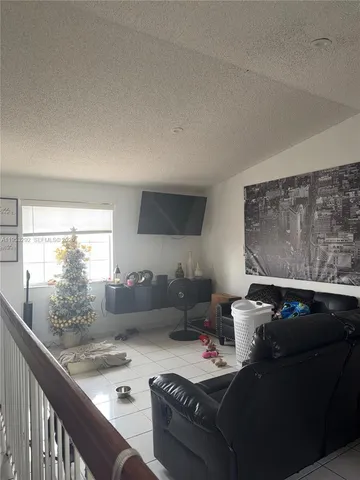 a living room with furniture and a floor to ceiling window