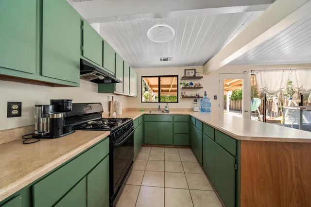 a kitchen with stainless steel appliances granite countertop a sink a stove top oven and cabinets