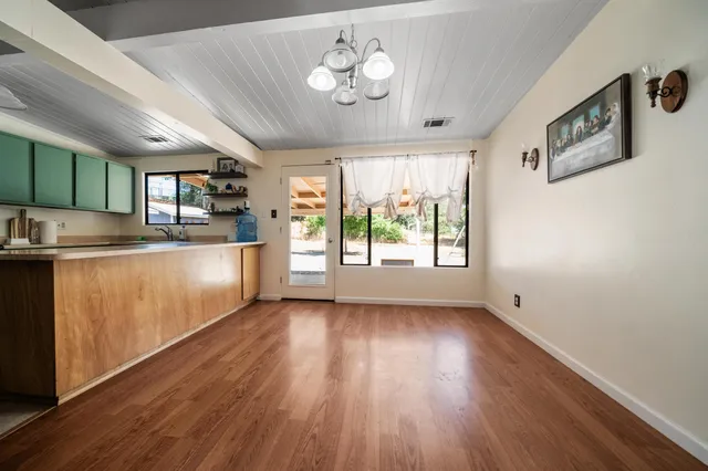 a kitchen with stainless steel appliances granite countertop a stove a sink dishwasher and a refrigerator with wooden floor