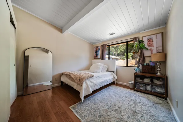 a bedroom with a bed next to a large window with outer view