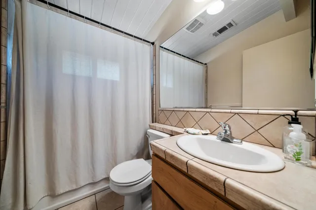 a bathroom with a sink a toilet and a mirror