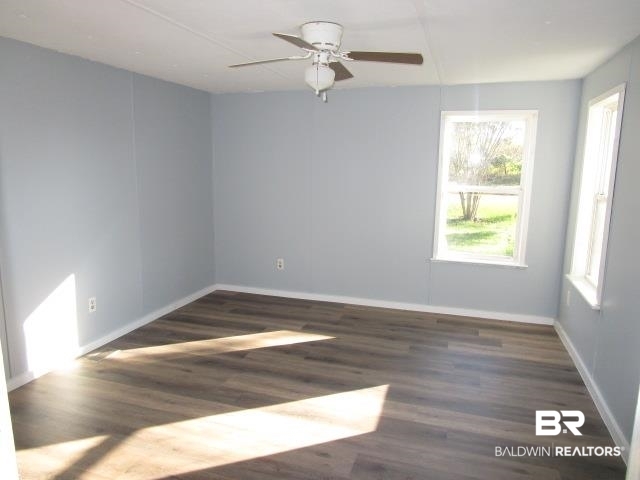 14791 Raber Road Summerdale, AL 36580 - Photo 12 of 21 Empty room featuring ceiling fan and dark wood-type flooring
