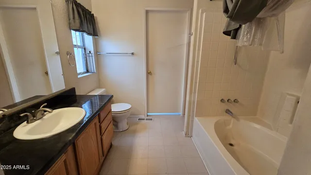 an empty room with a ceiling fan and carpet