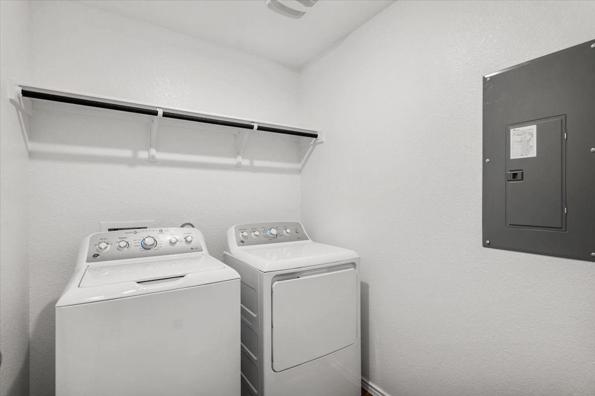 167 Jeffers Kyle, TX 78640 - Photo 21 of 40 Laundry area featuring electric panel, separate washer and dryer, and a textured wall
