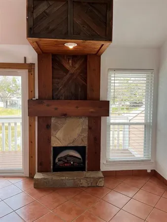a view of an empty room with a fireplace and a window