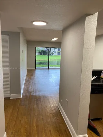 a view of a room with wooden floor and a window
