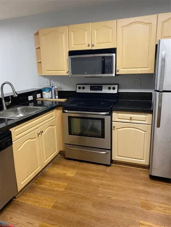 a kitchen with stainless steel appliances a stove microwave and sink
