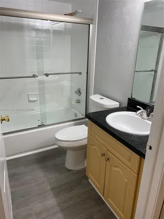 a bathroom with a granite countertop toilet sink and shower