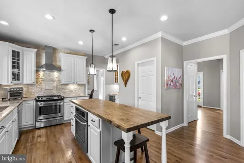 a kitchen with kitchen island a counter top space wooden floor and a ceiling fan
