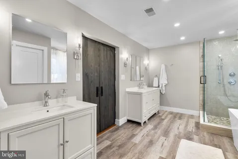 a bathroom with a bathtub a shower and a window