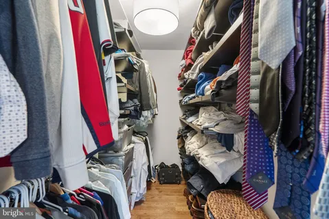 a view of walk in closet with clothes and shoes
