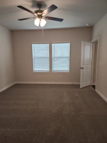 en empty room with windows and fan