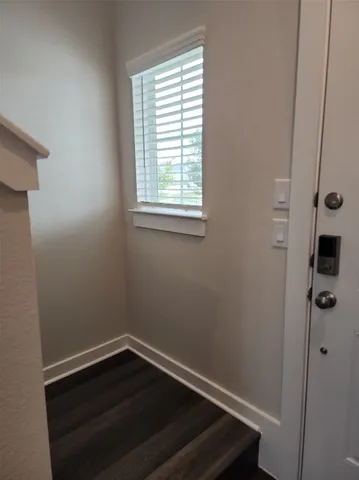 a view of small space with wooden floor and a window