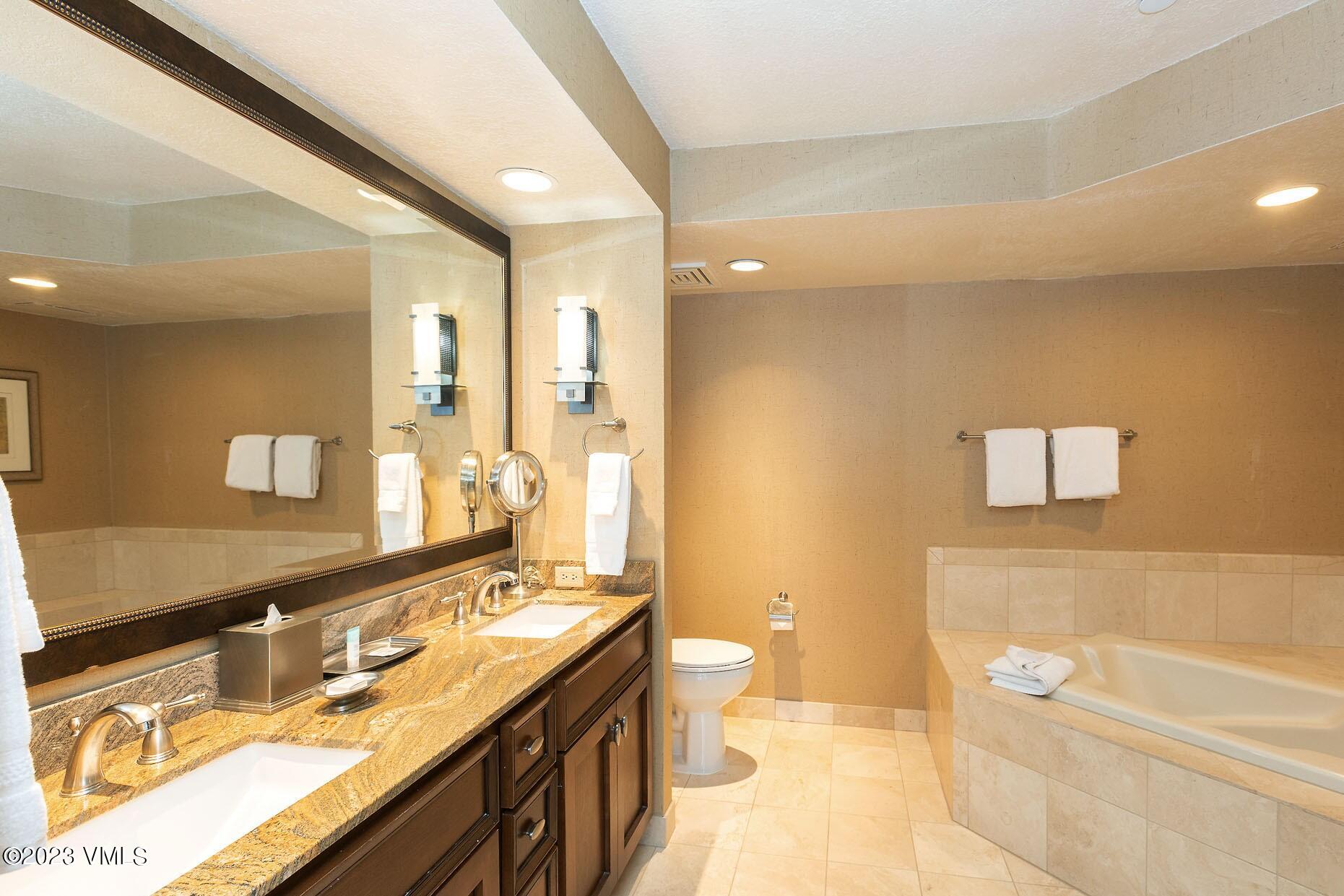 210 Offerson Road, Unit 115 WEEK 33 Beaver Creek, CO 81620 - Photo 19 of 23 a bathroom with a granite countertop sink a large mirror and a bathtub