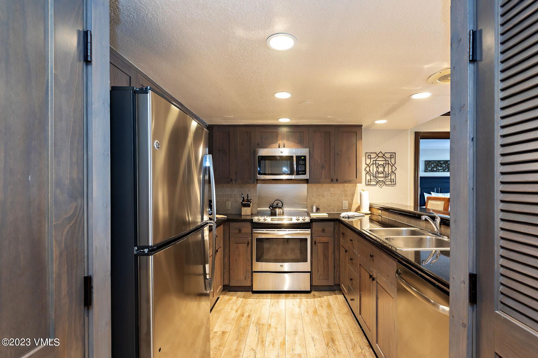 210 Offerson Road, Unit 115 WEEK 33 Beaver Creek, CO 81620 - Photo 6 of 23 a kitchen with stainless steel appliances granite countertop a sink stove and refrigerator