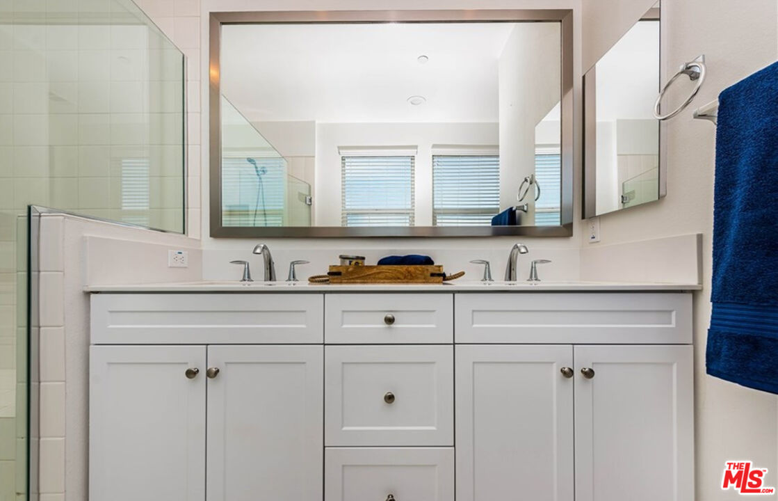 5304 Harvard Way Cypress, CA 90630 - Photo 14 of 29 a bathroom with cabinets a sink and a mirror
