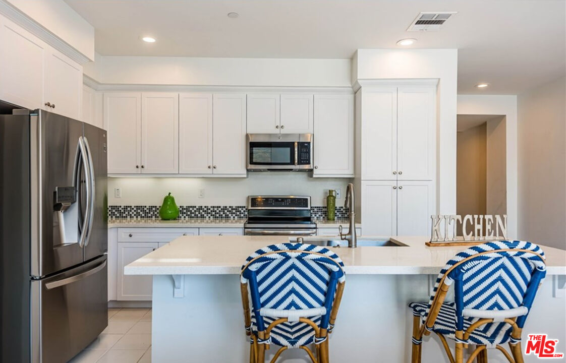 5304 Harvard Way Cypress, CA 90630 - Photo 3 of 29 a kitchen with stainless steel appliances granite countertop a refrigerator and a stove top oven
