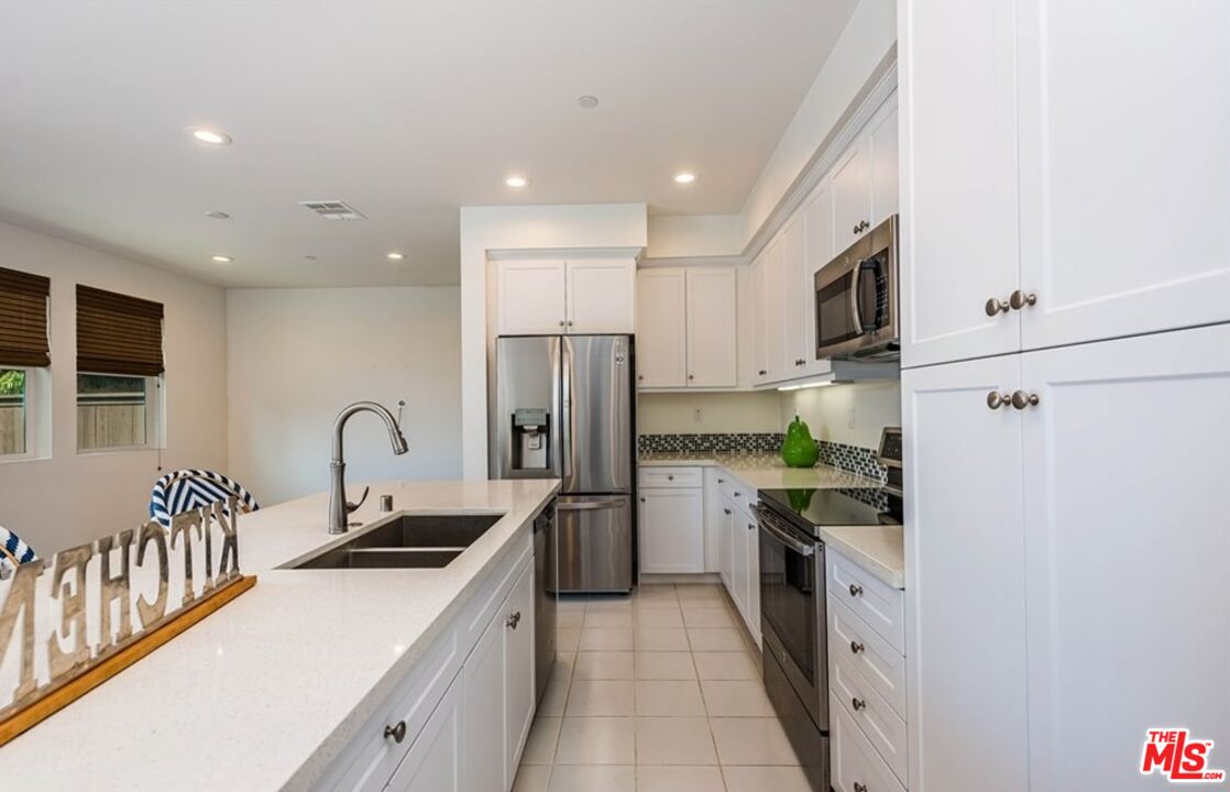 5304 Harvard Way Cypress, CA 90630 - Photo 4 of 29 a kitchen with stainless steel appliances a refrigerator sink and white cabinets