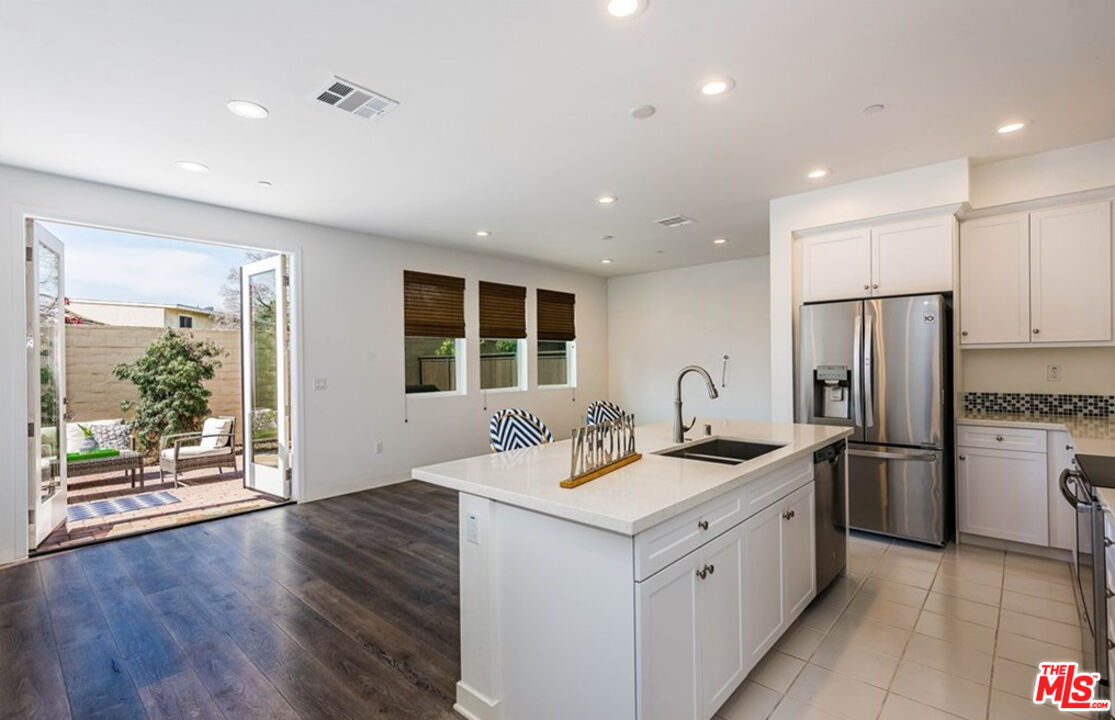 5304 Harvard Way Cypress, CA 90630 - Photo 10 of 29 a kitchen with stainless steel appliances granite countertop a sink stove and refrigerator