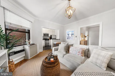 a living room with furniture and a chandelier