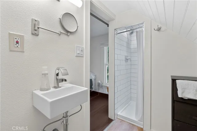 a bathroom with a sink mirror and shower