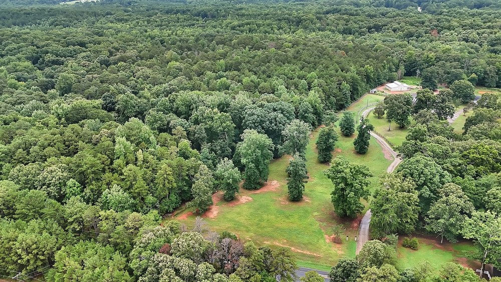 5 State Rd S-4-97 Anderson, SC 29621 - Photo 9 of 15 An aerial perspective reveals a winding driveway through a verdant, wooded landscape leading to a secluded estate.
