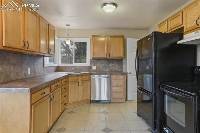 a kitchen with stainless steel appliances granite countertop a refrigerator and a sink