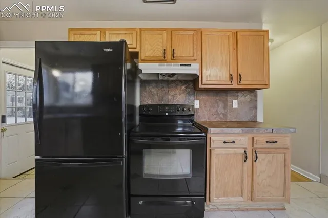 a kitchen with granite countertop white cabinets and refrigerator