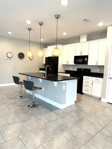 a kitchen with a sink a counter top space appliances and cabinets