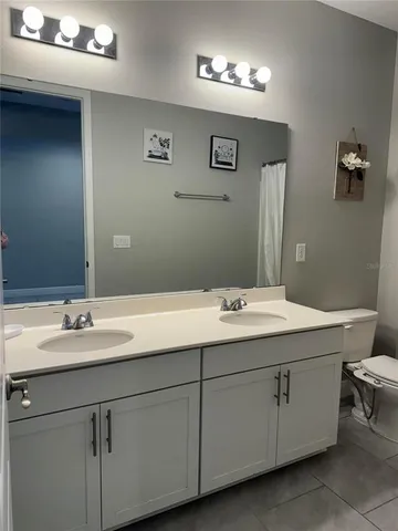 a bathroom with a double vanity sink and a mirror