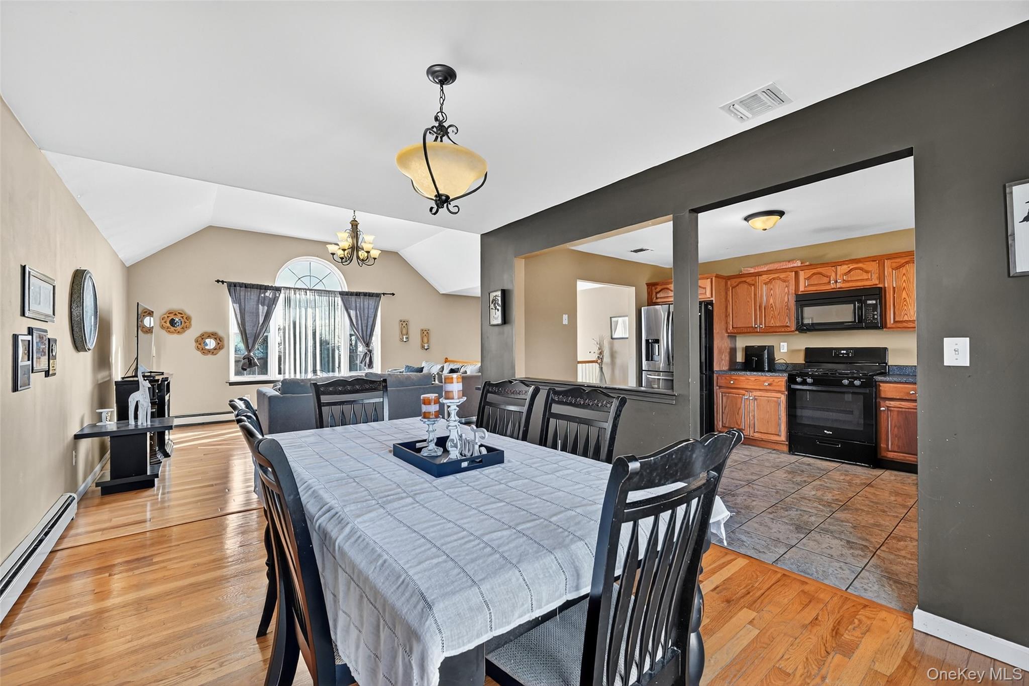 913 Silver Lake Sctn Road Middletown, NY 10941 - Photo 8 of 29 a view of a dining room and livingroom with furniture wooden floor a rug a painting and a chandelier
