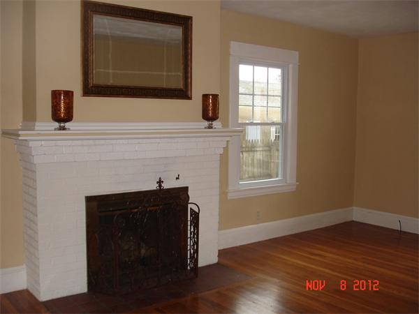 58 Castle Street Springfield, MA 01118 - Photo 5 of 21 a living room with a fireplace and wooden floor