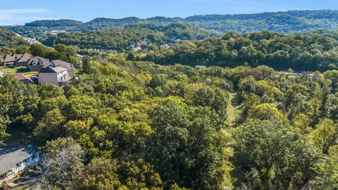 an aerial view of a houses with a lush green hillside