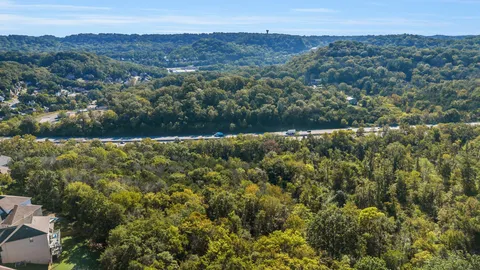 an aerial view of residential houses with outdoor space and trees