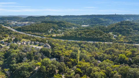 an aerial view of residential houses with outdoor space and trees