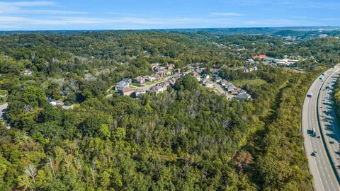 an aerial view of residential houses with outdoor space and trees