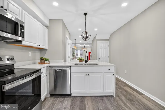 a kitchen with stainless steel appliances a sink stove and microwave