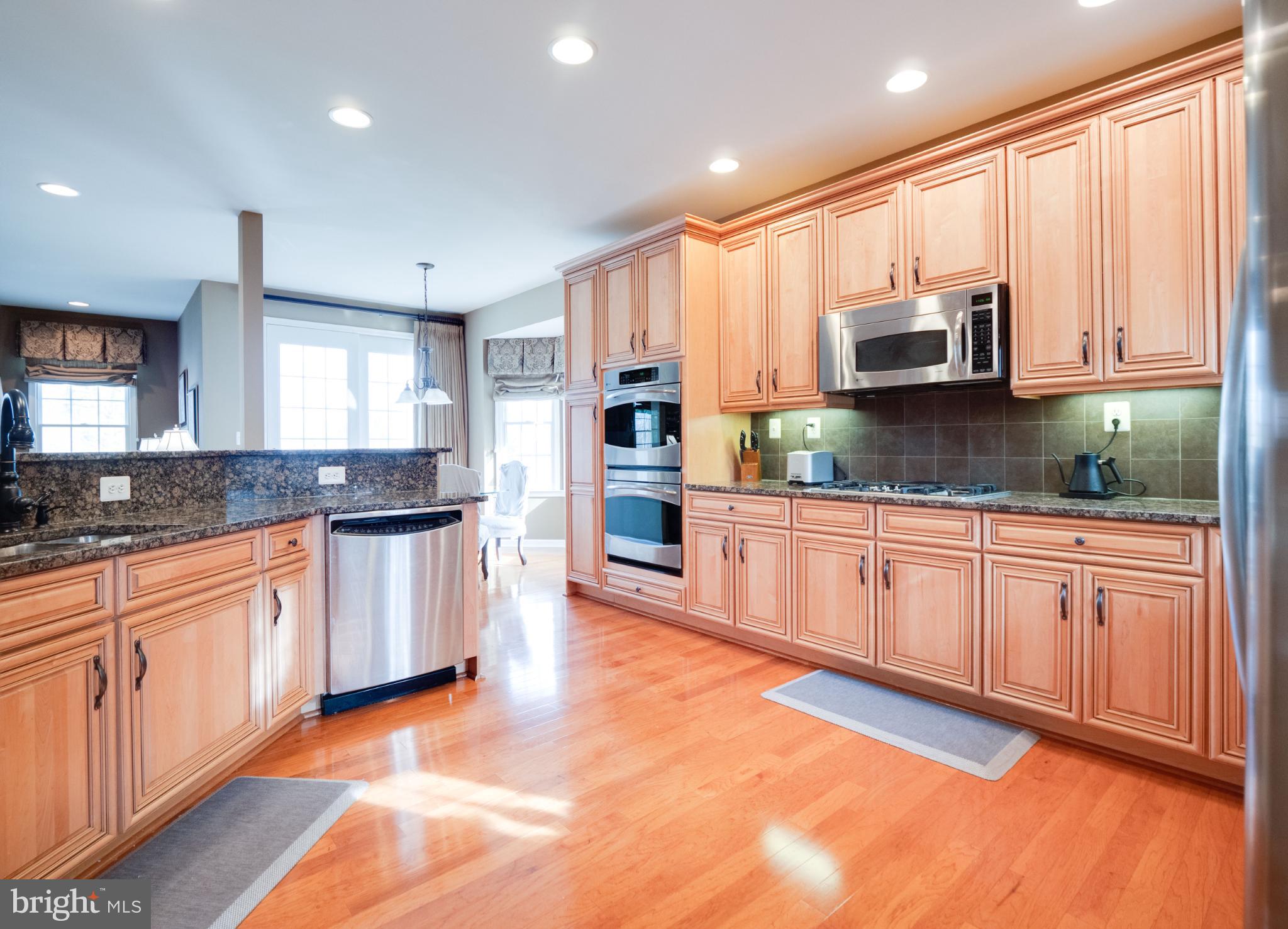 23152 Evergreen Ridge Drive Ashburn, VA 20148 - Photo 14 of 72 Elegant kitchen with warm wood cabinetry.