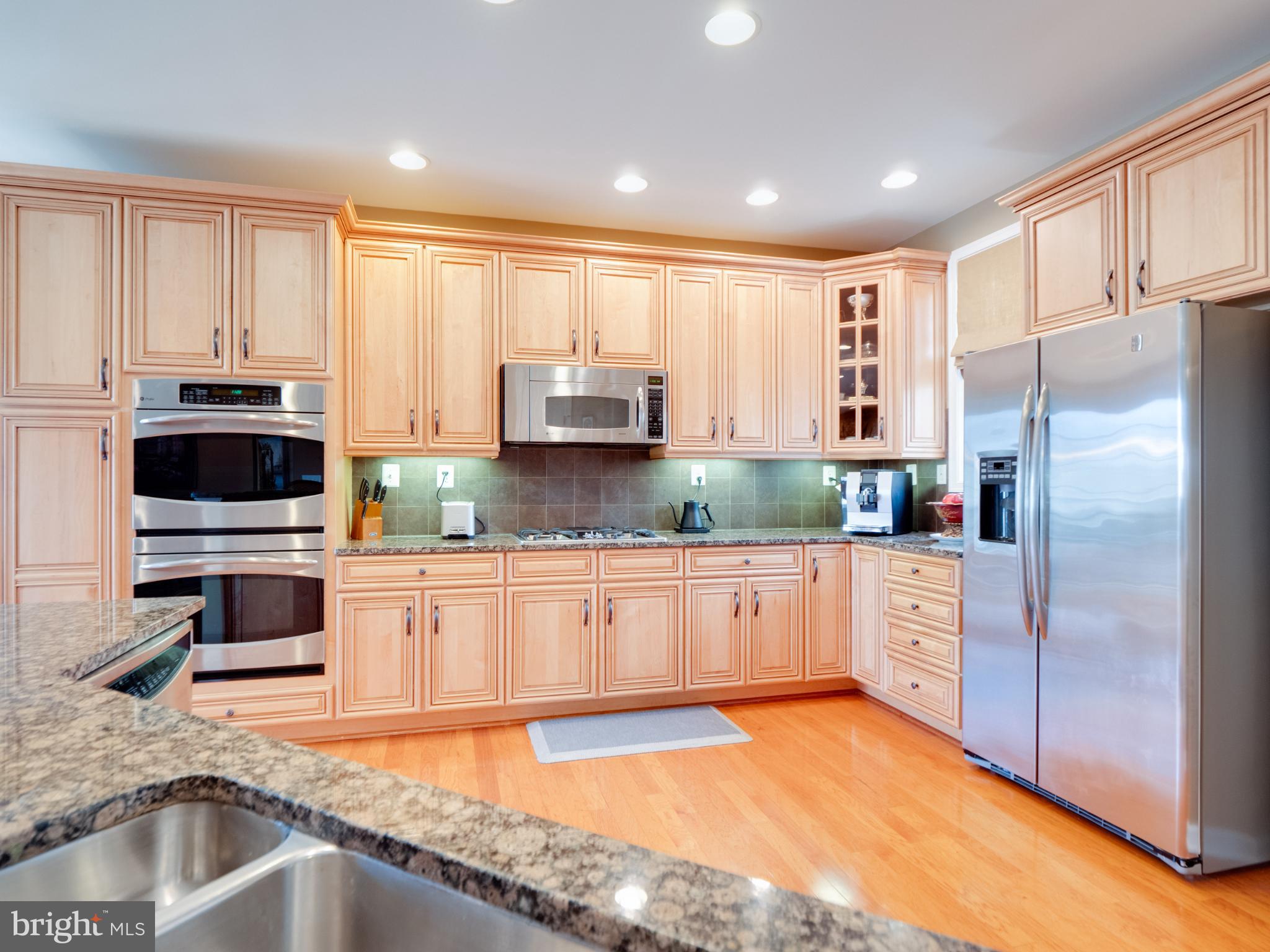 23152 Evergreen Ridge Drive Ashburn, VA 20148 - Photo 15 of 72 Elegant kitchen with warm wood cabinetry.