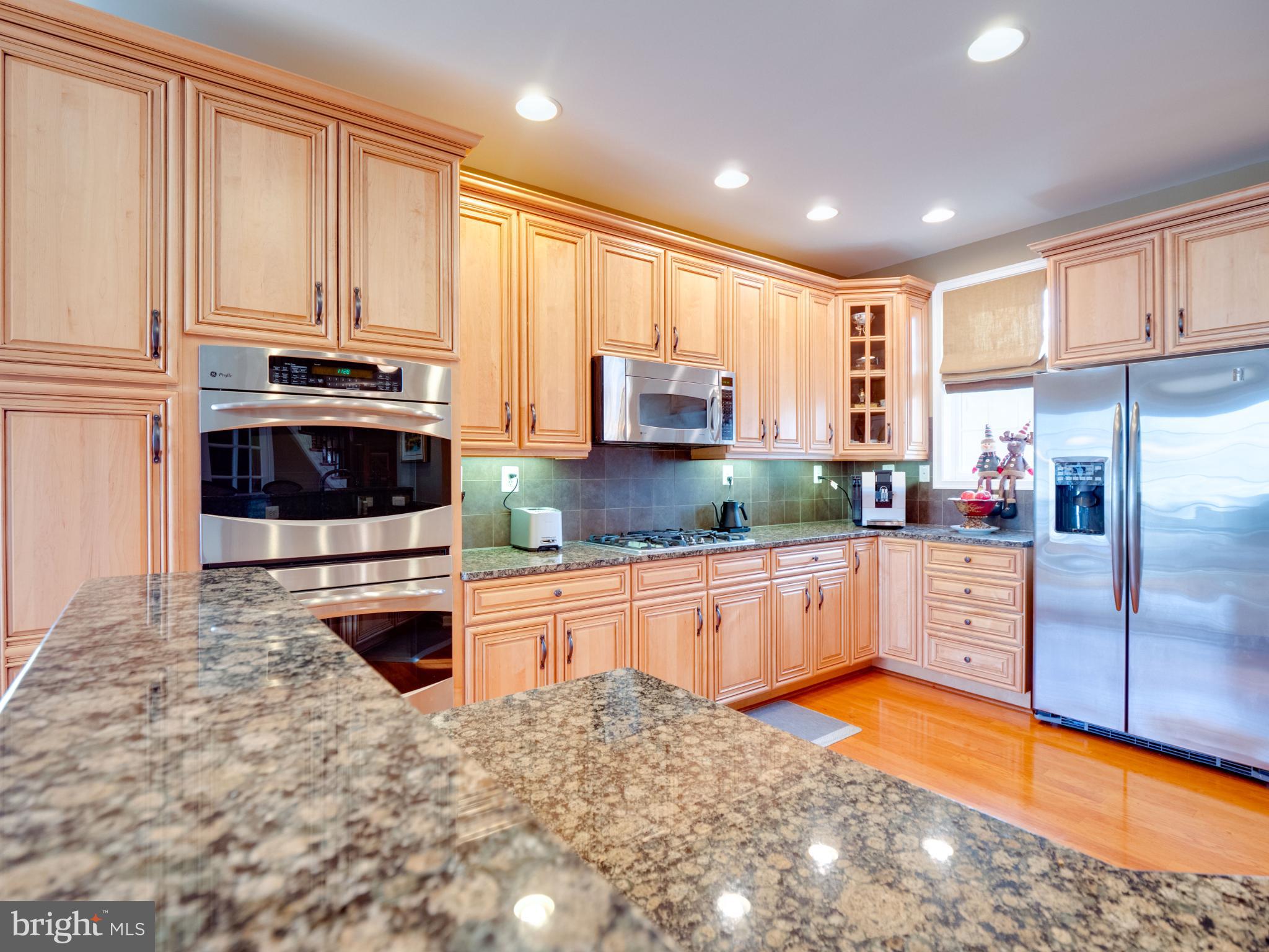 23152 Evergreen Ridge Drive Ashburn, VA 20148 - Photo 16 of 72 Elegant kitchen with warm wood cabinetry.