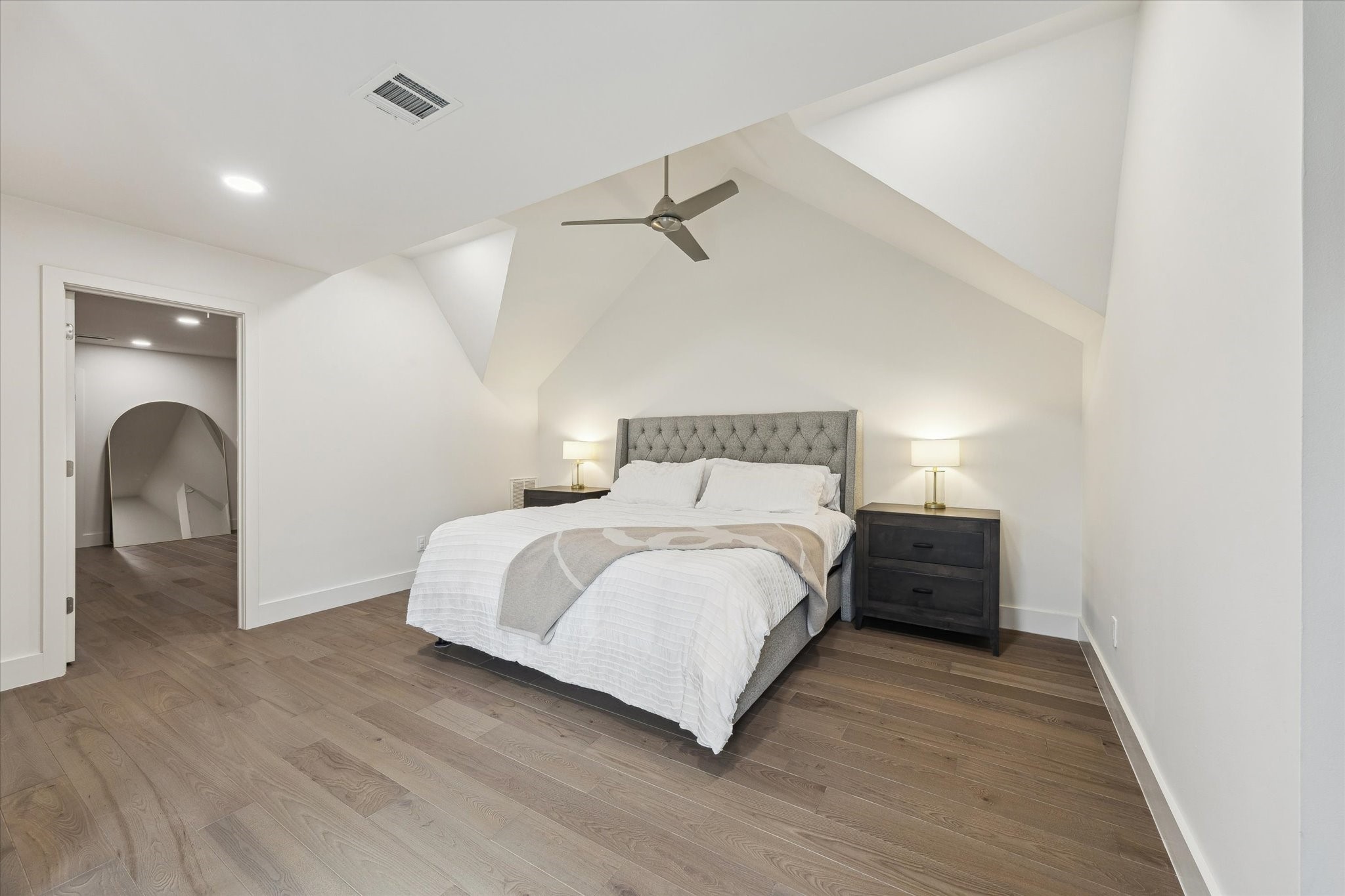 6348 Vanderbilt Street West University Place, TX 77005 - Photo 24 of 30 A true second primary suite. Vaulted ceilings, warm hardwood floors, a generous walk-in closet, and a private ensuite make this upper-level retreat as compelling as the one downstairs — ideal for multigenerational living, long-term guests, or simply a household that refuses to compromise on comfort.