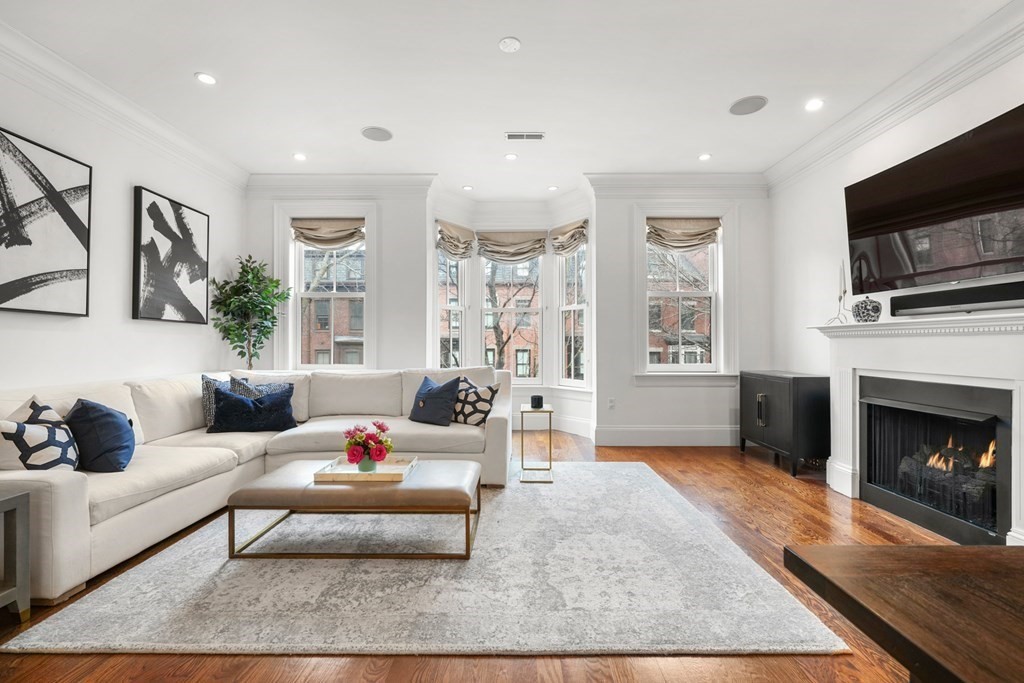a living room with furniture a flat screen tv and a fireplace