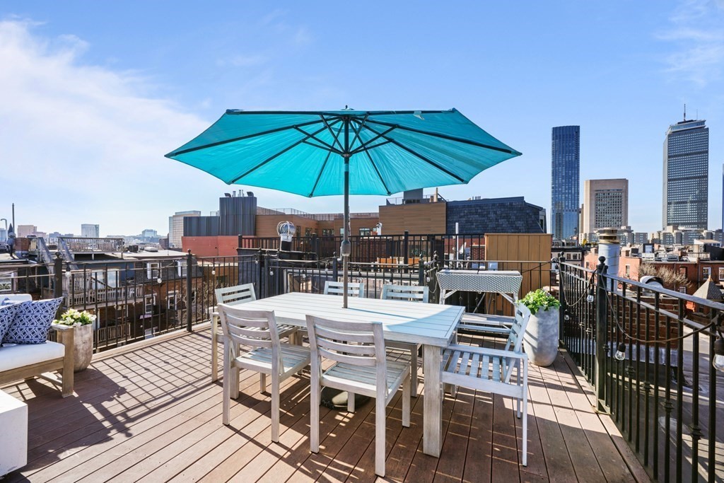 212 West Springfield Street, Unit 2 Boston, MA 02118 - Photo 38 of 41 a view of a roof deck with table and chairs under an umbrella
