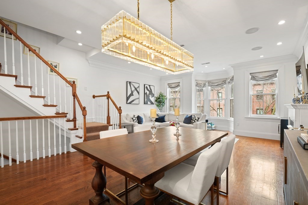 212 West Springfield Street, Unit 2 Boston, MA 02118 - Photo 4 of 41 a dining room with wooden floor a chandelier a wooden table and chairs