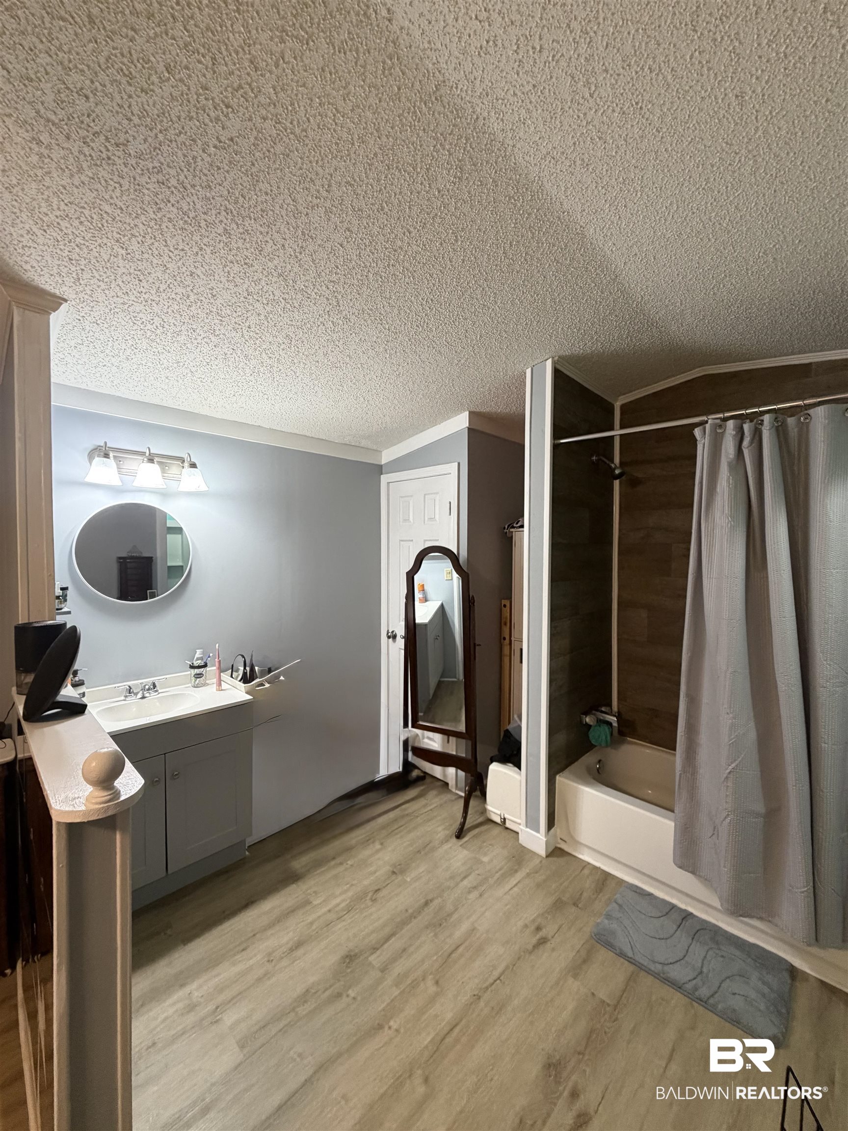1913 Maria Lane Lillian, AL 36549 - Photo 11 of 35 Bathroom featuring vanity, shower / bath combination with curtain, crown molding, light wood-style flooring, and a textured ceiling