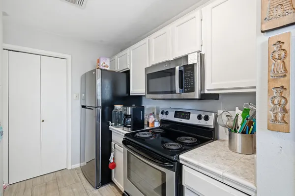 a kitchen with stainless steel appliances a stove a microwave a refrigerator a stove and cabinets