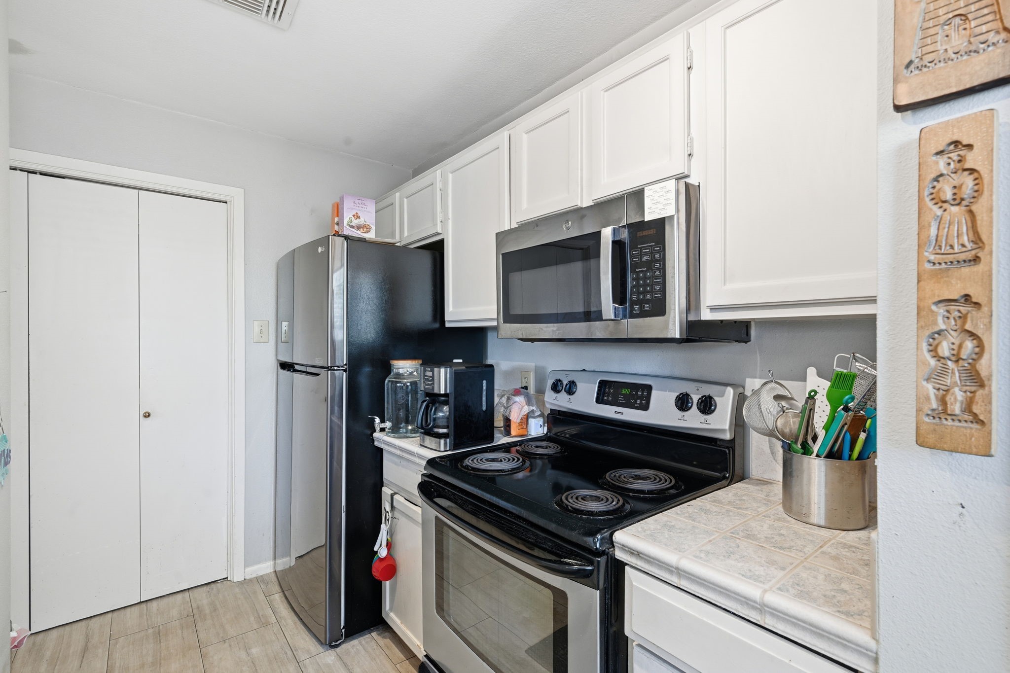 4 Sawmill Grove Lane Spring, TX 77380 - Photo 13 of 27 a kitchen with stainless steel appliances a stove a microwave a refrigerator a stove and cabinets