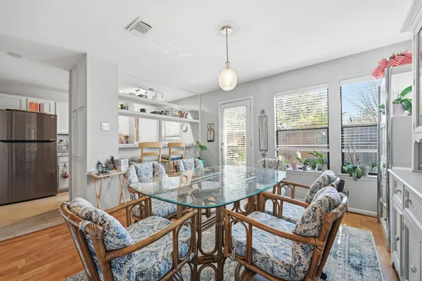 a dining room with furniture a chandelier and wooden floor