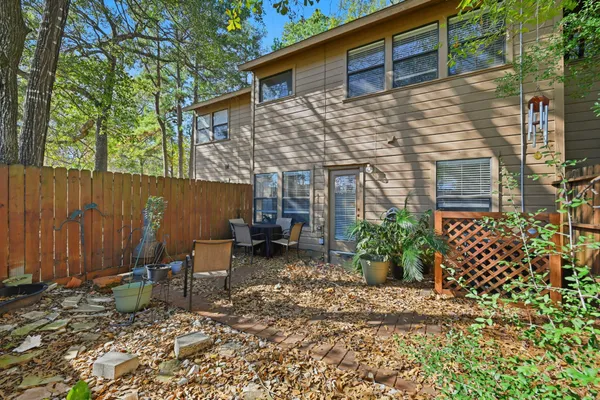 a backyard of a house with potted plants and covered with trees
